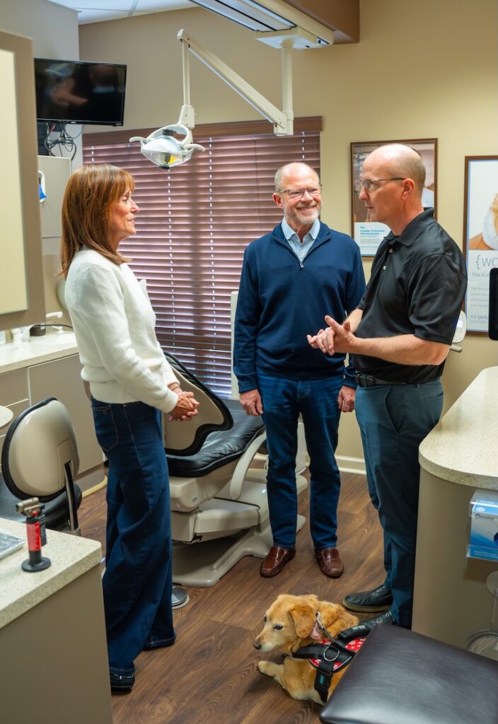 Doctor discussing with patients and dog