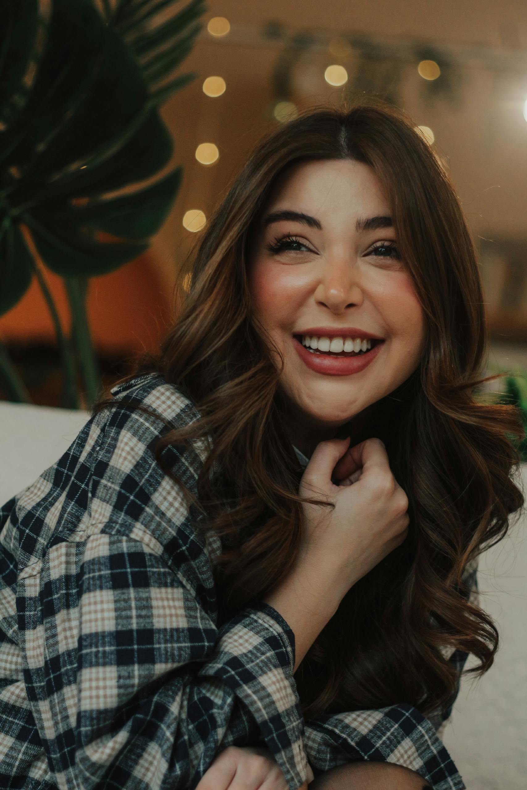 Portrait of a smiling woman indoors with cozy lighting, capturing a joyful moment in Baku.